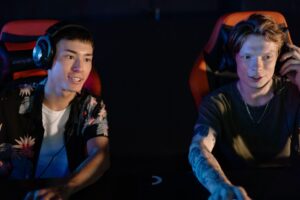 Two gamers wearing headsets and playing a competitive computer game during an esports gaming session.